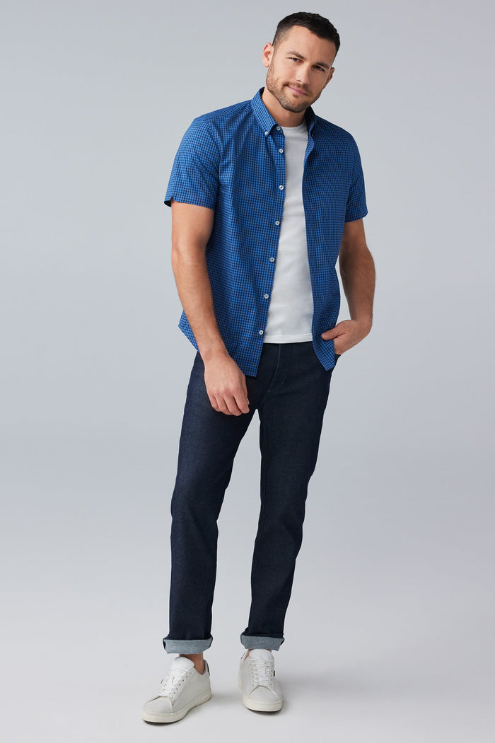 Full body front view of man wearing 24/7 Poplin Short Sleeve Shirt in True Navy Crosshatch