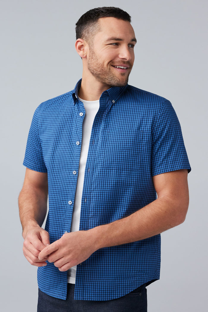 Front view of man wearing 24/7 Poplin Short Sleeve Shirt in True Navy Crosshatch