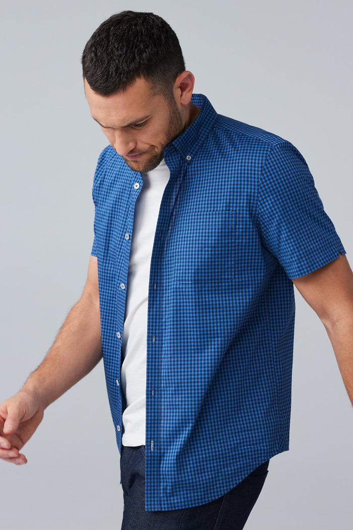Side view of man wearing 24/7 Poplin Short Sleeve Shirt in True Navy Crosshatch