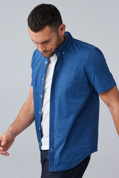 Side view of man wearing 24/7 Poplin Short Sleeve Shirt in True Navy Crosshatch