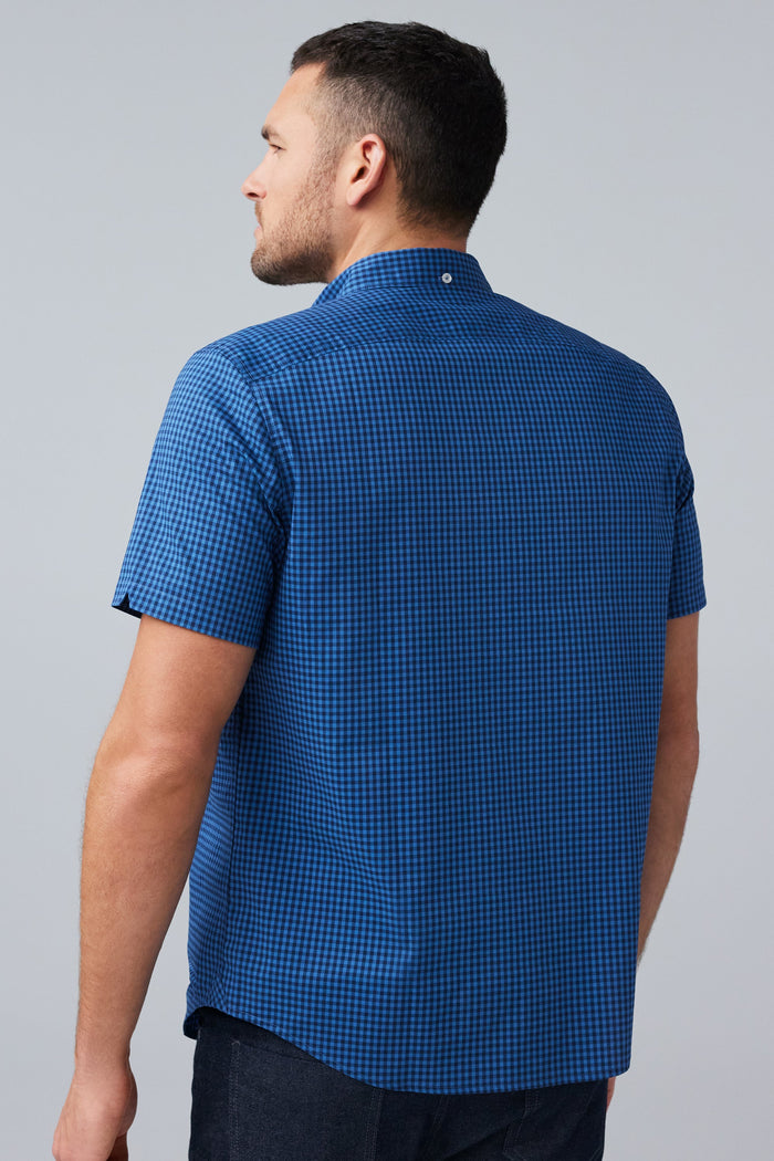 Back view of man wearing 24/7 Poplin Short Sleeve Shirt in True Navy Crosshatch