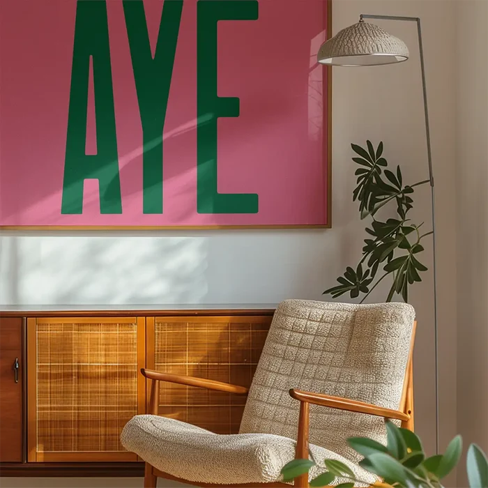 Aye Pink Typography Poster Print in an oak frame on a dining table