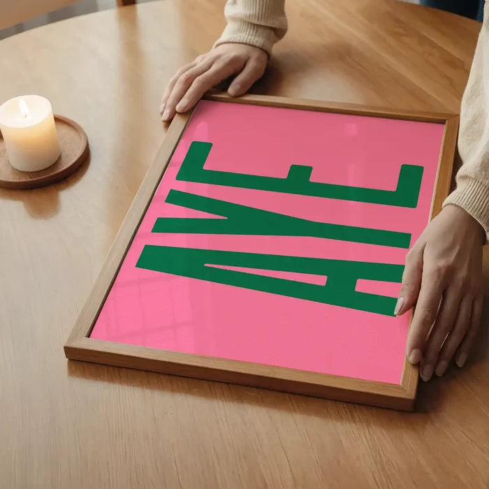 Aye Pink Typography Poster Print in an oak frame on a dining table (2)