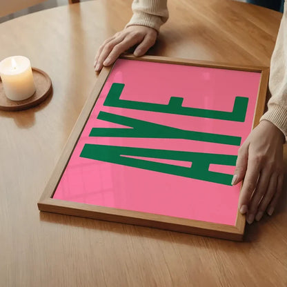 Aye Pink Typography Poster Print in an oak frame on a dining table (2)