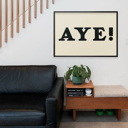 Aye Typography Poster Print framed above a living room sofa