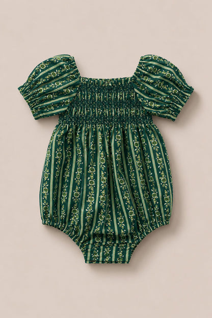 The Ivy City Co Baby Sunday Best Romper in Pine Felicity Floral features short puffed sleeves, a smocked chest, and vertical floral stripes on a beige background.