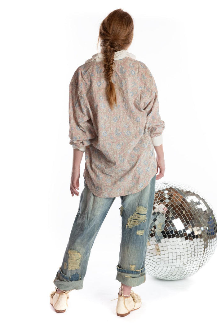 Woman in Magnolia Pearl vintage floral shirt and distressed jeans with disco ball, artisan clothing