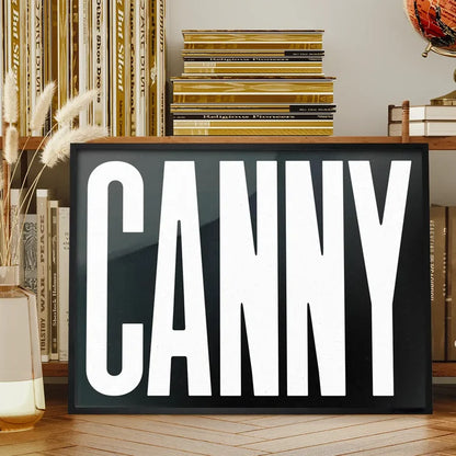 Canny Typography Poster Black and White Print framed on a living room bookshelf