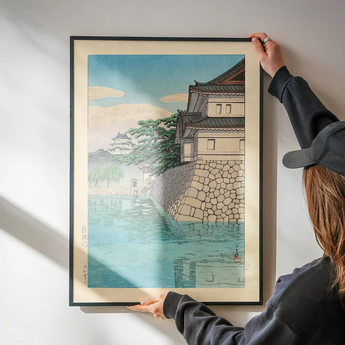 Kikyomon Gate Print by Hasui Kawase being hung on a wall in a black frame