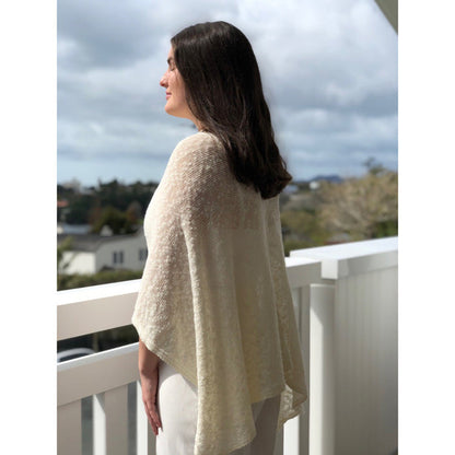 Woman wearing cotton poncho. Colour Cream