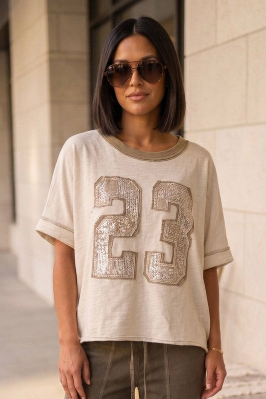 Boho boutique oversized neutral tee with sequin 23 graphic styled with olive wide leg lounge pants and casual sandals for an effortless everyday outfit look.