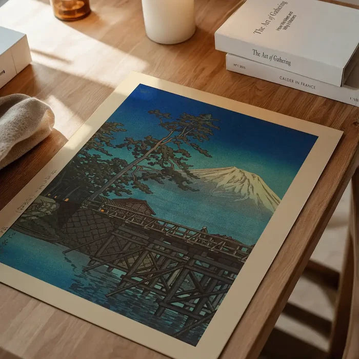 Mt. Fuji in Moonlight and Kawaibashi Bridge Print by Hasui Kawase, Japanese woodblock print unframed on a home office desk