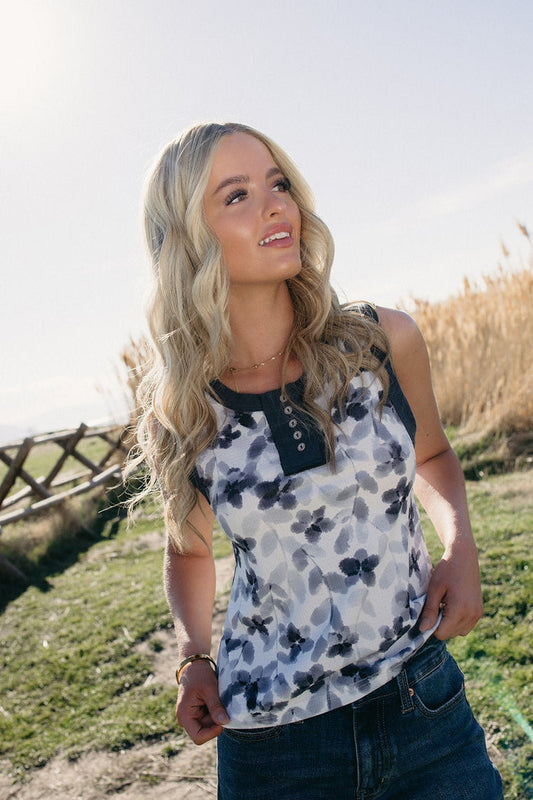 Lightweight sleeveless POL floral henley tank top styled with denim for summer outfits, lake day looks, country concert nights, beach town vacations, rodeo weekends, casual BBQ outfits, and effortless boho western summer fashion from Sand + Charcoal Boutique.