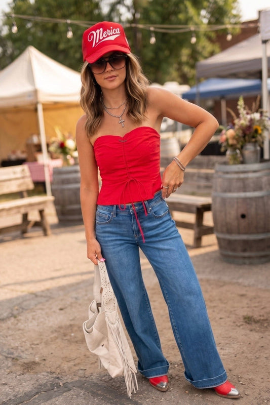 Red strapless summer top featuring a sweetheart neckline, adjustable lace-up detail, ruffle trim, and flattering fitted silhouette.