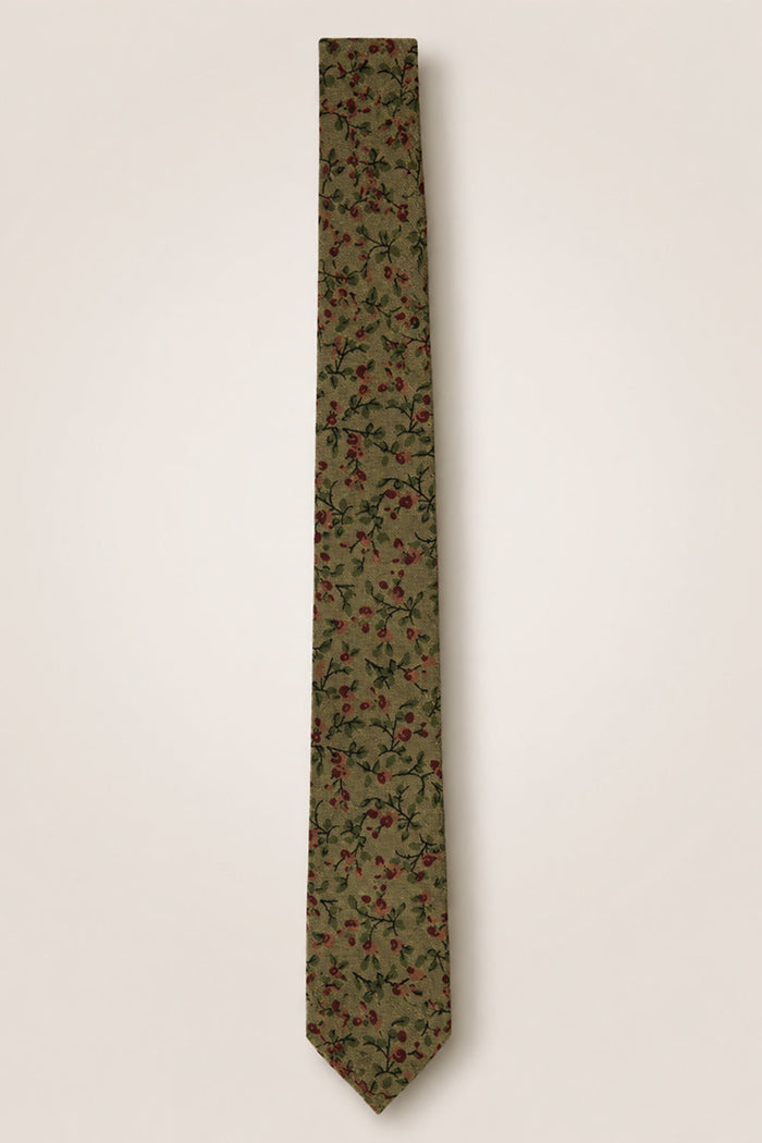 The Ties in Woodland Floral by Ivy City Co showcase an olive green cotton fabric adorned with a delicate pattern of small red flowers and green leaves, displayed flat against a plain light background—an elegant accessory perfect for any nature-inspired wedding celebration.