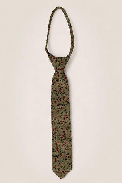 The Ivy City Co “Ties in Woodland Floral” showcases a khaki green cotton fabric adorned with a red and black woodland floral pattern. Displayed against a simple light background and tied in a classic knot with an adjustable loop, this tie is an understated yet charming wedding accessory.
