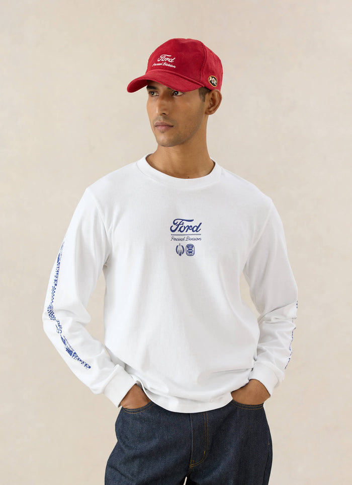 A model wears the white Ford x Percival Triple Triumph organic cotton long sleeve t-shirt with dark indigo heritage denim.