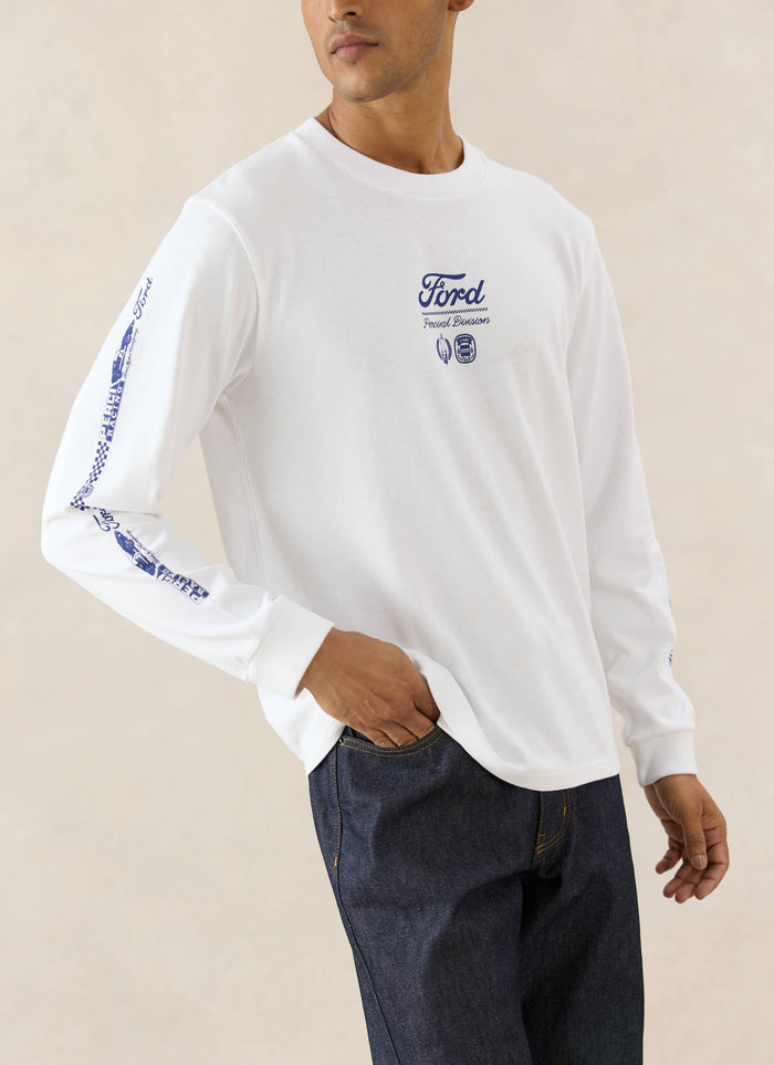 White Ford x Percival long sleeve t-shirt with motorsport graphics, styled with straight-leg heritage raw denim jeans.