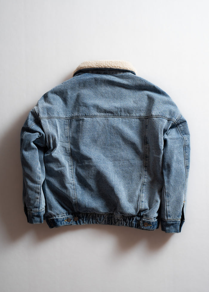 Denim jacket with a sherpa collar, displayed on a plain background, showcasing its back view and classic style.