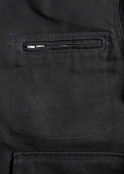 Close-up of a black fabric jacket pocket with a visible zipper, showcasing detailed stitching and texture.