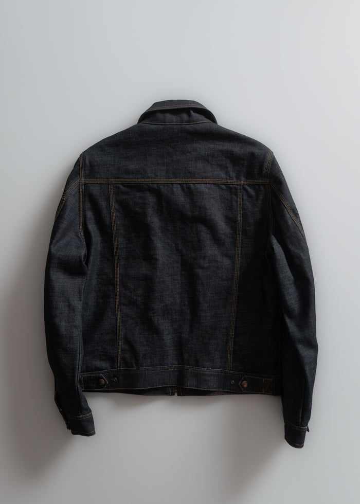 Dark denim jacket with visible stitching, displayed from the back against a plain light gray background, highlighting its texture.