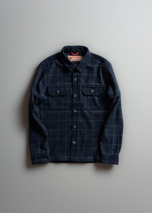 Dark plaid button-up shirt with two chest pockets, laid flat on a light gray background.